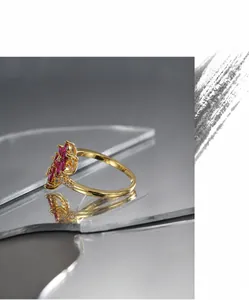 Macro di anello a fiore dorato con gemme marquise rosa e dettagli in pavé scintillanti