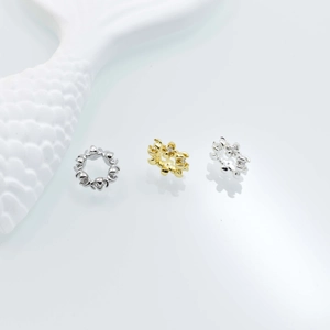 Macro shot of silver and gold flower spacer beads with tiny zircon crystals for jewelry