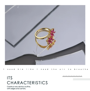Dettaglio ravvicinato dell'anello in oro 18K con due fiori in zircone rosso e piccoli cristalli