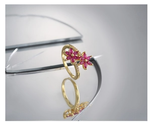 Dettaglio macro di anello a fiore in oro 18K con petali rosa e cristalli scintillanti