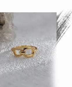 Macro view of gold plated brass ring featuring twisted rope and buckle design