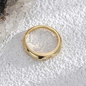 Polished gold-plated wide band ring featuring a delicate star engraving on a white surface