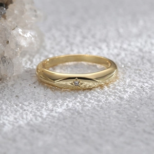 Macro shot of gold star-embossed ring with embedded zircon on textured background