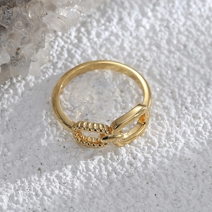 Minimalist gold plated asymmetric buckle ring featuring textured rope and smooth bands