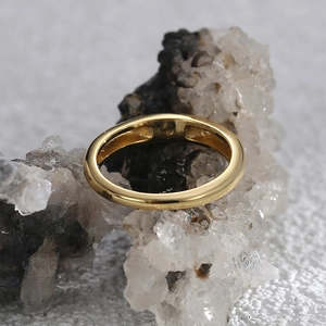 Minimalist gold ring with polished finish displayed on a natural white crystal cluster