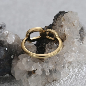 Detailed macro view of gold-plated chain link ring with beaded texture on crystal stone