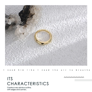 Detailed view of wide 18K gold geometric ring with polished finish on mineral stone