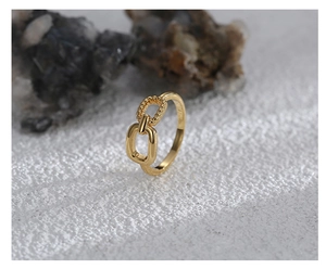 Macro detail of gold-plated brass ring featuring twisted rope texture and interlocking link
