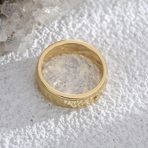 Minimalistischer goldener Breitbandring mit Sternengravur auf weißem Kristallgrund