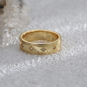 Details eines Vintage-Goldrings mit Sternengravur und zentralem Zirkonia-Stein