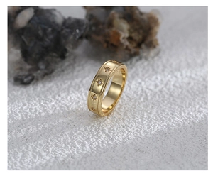 Detailaufnahme des Goldrings mit Sternenmuster und Zirkonia auf texturierter Schiene