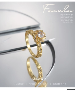 Macro shot of gold floral ring featuring a central zircon stone and paved diamonds