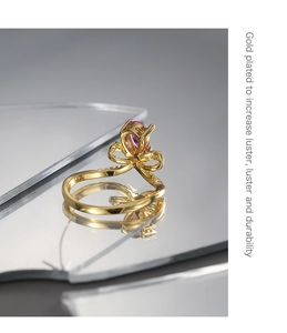 Detalle del anillo bañado en oro con circón púrpura y detalles brillantes en forma de lazo
