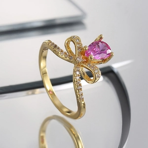 Elegante anillo de lazo dorado para mujer con circón rosa pera y pavé de piedras blancas