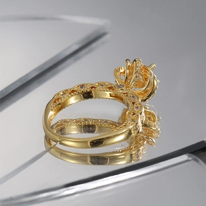 Vintage gold crown ring with hollow floral design and zircon stones on a mirror base