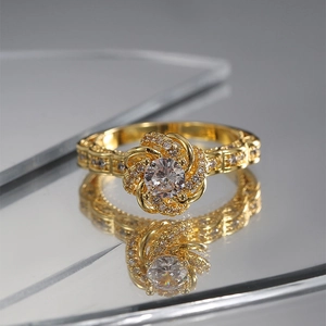 Rotating floral gold ring with sparkling zircon stone on a reflective mirror background