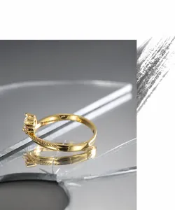 Close-up of beaded gold ring featuring sparkling white and pink cubic zirconia accents