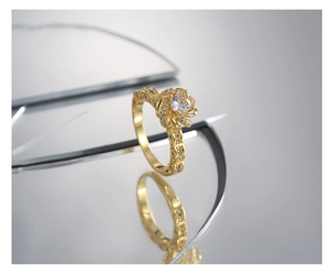 Macro shot of gold vintage flower ring featuring a zircon center and floral openwork band