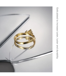 Macro detail of gold plated ring with round zircon and beaded texture on broken glass