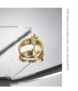 Detail eines vergoldeten Rings mit Marquise-Zirkon und roten Steinen auf Spiegel