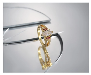 Makroaufnahme des vergoldeten Rings mit Marquise-Zirkon, roten Steinen und Pavé-Detail