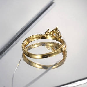 Macro detail of gold-plated ring featuring two clear zircons and beaded edge texture