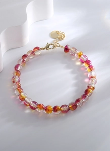 Détail d'un bracelet en perles de verre colorées avec fermoir mousqueton doré