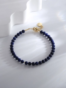 Close-up of deep blue beaded bracelet with gold lobster clasp and adjustable chain