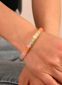 Détail d'un bracelet en perles macaron mates colorées au poignet au style estival