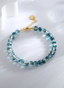 Gros plan d'un bracelet en perles turquoise avec texture craquelée et fermoir mousqueton doré