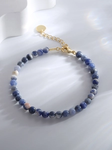 Detail of blue marble stone bead bracelet with gold lobster clasp and extension chain