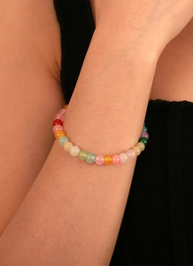 Gros plan d'un bracelet en perles colorées au poignet avec des perles translucides vives