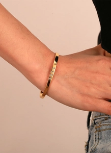 Close-up of gold plated brass bracelet with four cubic zirconia stones on model wrist