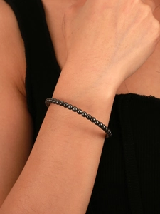Close-up of minimalist black hematite beaded bracelet worn on a female wrist
