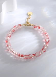 Détail du bracelet avec perles en cristal de fraise rouge et fermoir mousqueton doré