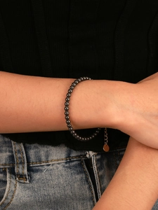 Detail of dark grey hematite beaded bracelet with gold extension chain on wrist