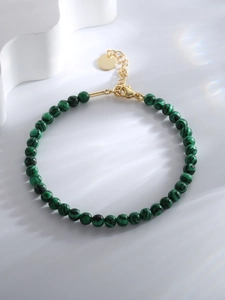 Detail of green malachite style beaded bracelet with gold clasp and adjustable chain
