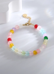 Détail d'un bracelet en perles colorées avec fermoir mousqueton doré et chaîne