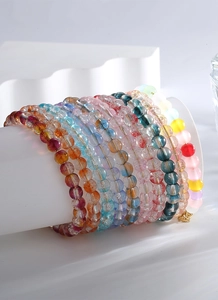 Vue détaillée de bracelets de perles colorées à paillettes sur un support blanc