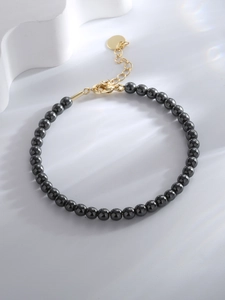 Detail of beaded hematite bracelet featuring high-polish black beads and gold clasp