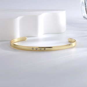 Polished gold plated cuff bracelet for women featuring four minimalist round zircons