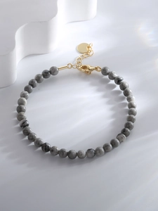 Detail of marble beaded bracelet featuring gold-plated lobster clasp and extension chain