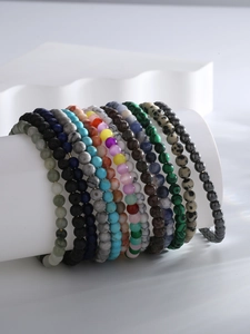 Close-up of assorted 8mm natural stone bead bracelets in various vibrant colors