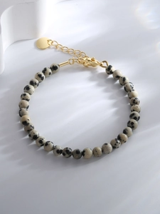 Close-up of marble stone beads bracelet with adjustable golden lobster clasp and tag