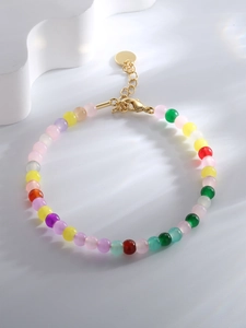 Close-up of multi-color beads with golden lobster clasp and adjustable tail chain
