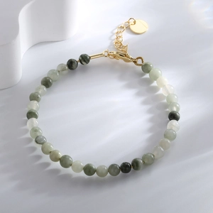 Elegant beaded bracelet with green and white stone beads and gold adjustable chain