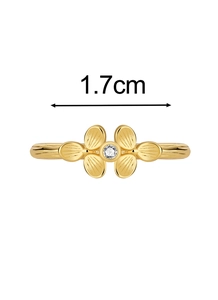 Detail showing gold flower ring with clover petals and a zircon stone in the center