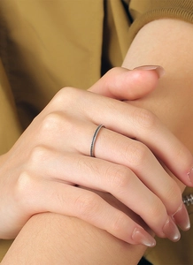 Detailansicht eines minimalistischen Retro-Silberrings mit Punkttextur am Finger eines Models