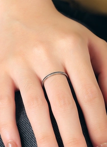 Makro-Detailansicht eines minimalistischen Silberrings mit Perlenkante am Finger