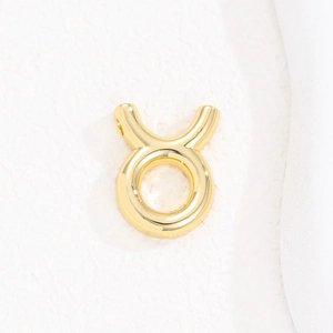 Detailed view of polished golden Taurus zodiac pendant with mirror finish and smooth curves